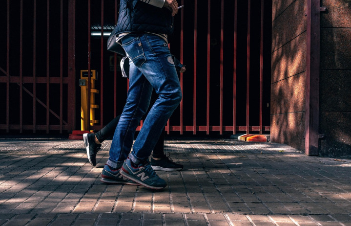 man moving wheelie bin sidewalk